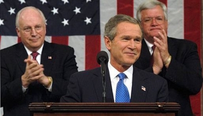 Dick Cheney at the 2003 State of the Union address. Cheney is to the left, behind President George W. Bush. To the far right is Speaker of the House Dennis Hastert. White House photo by Eric Draper. [http://www.whitehouse.gov/news/releases)